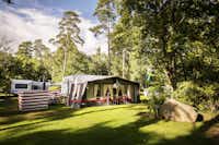 Nordic Camping Stensö - Blick auf das grüne Zeltplatz im Schatten der Bäume auf dem Campingplatz
