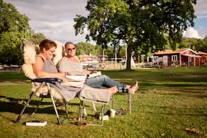Nordic Camping Stensö - Gäste vom Campingplatz am Lesen auf grüner Wiese