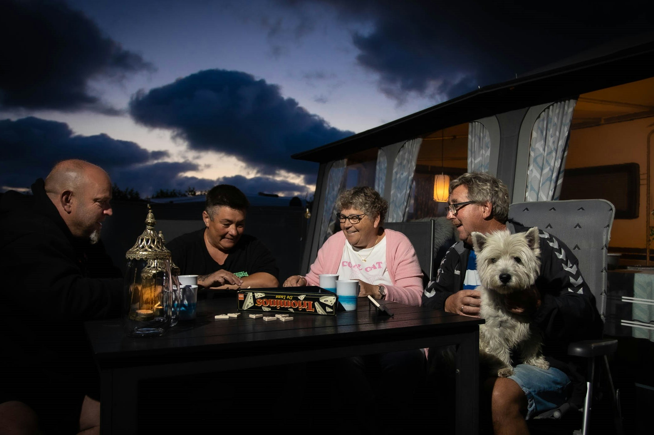 Stjerne Camping - Camper mit Hund sitzen am Abend vor ihrem Standplatz