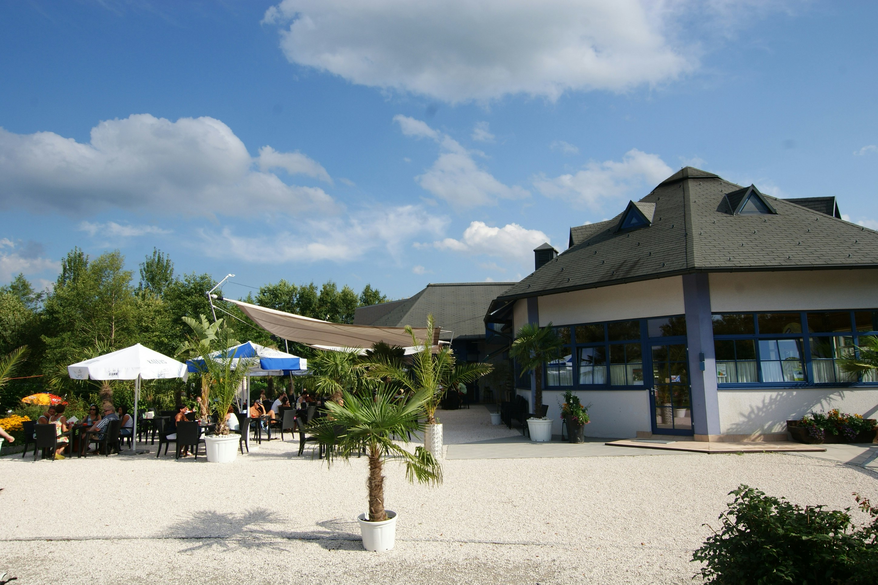Strandcamping Seekirchen - Restaurant mit Terrasse und Sonnenschirmen auf dem Campingplatz