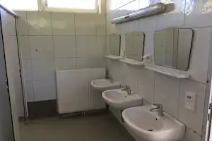 Strandcamping Seekirchen - Sanitärgebäude mit Waschbecken, Spiegel, Toiletten und Duschen