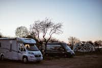 Sunny Nights Camping - Wohnmobile auf dem Parkplatz mit Iglogestell im Hintergrund