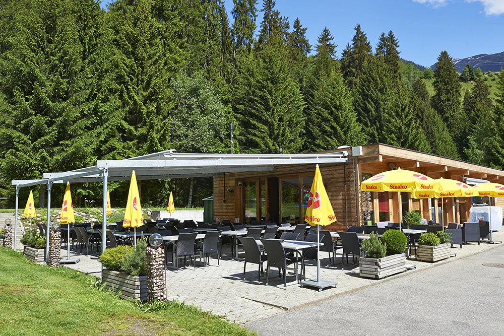 TCS-Camping Disentis - Außenansicht vom Restaurant mit Freiluftbereich auf dem Campingplatz