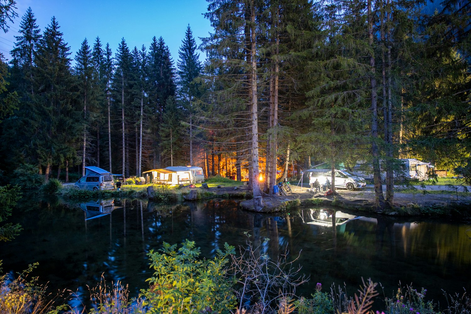 TCS-Camping Disentis - Blick vom anderen Ufer auf den Campingplatz am Abend