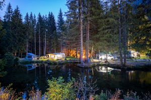TCS-Camping Disentis - Blick vom anderen Ufer auf den Campingplatz am Abend