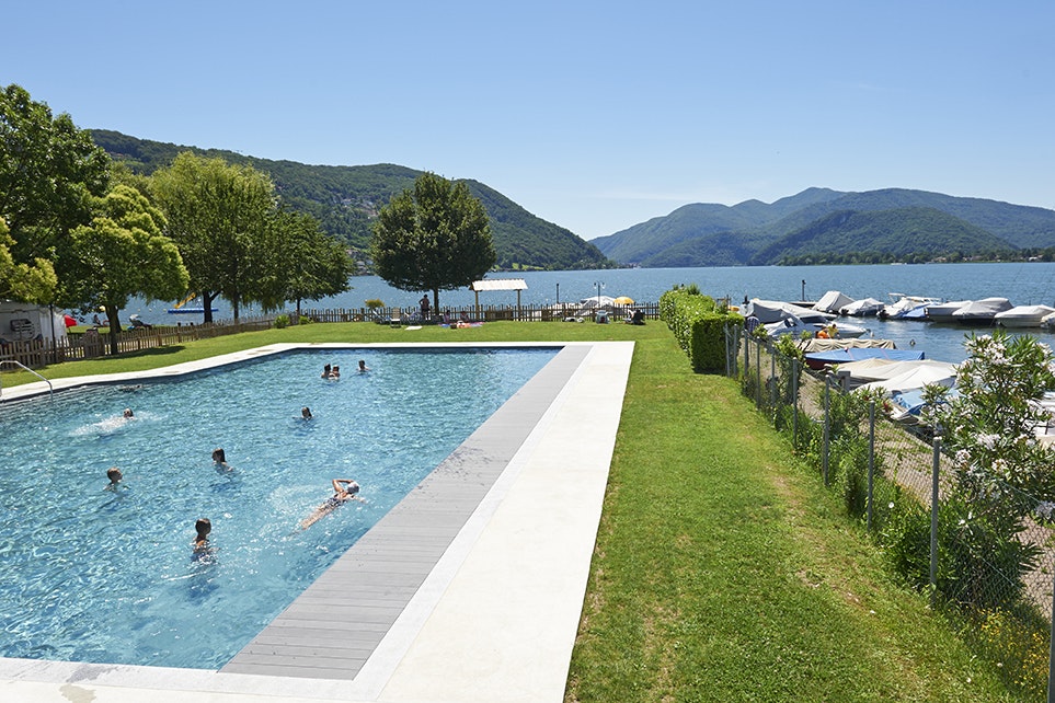 TCS-Camping Lugano - Poolbereich mit Blick auf Pier am Luganersee auf dem Campingplatz