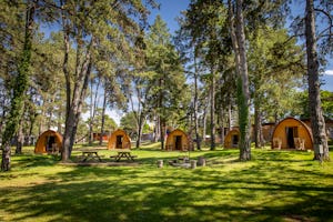 TCS Camping Orbe - Campingpods auf dem Campingplatz mit Picknicktischen und Feuerstelle