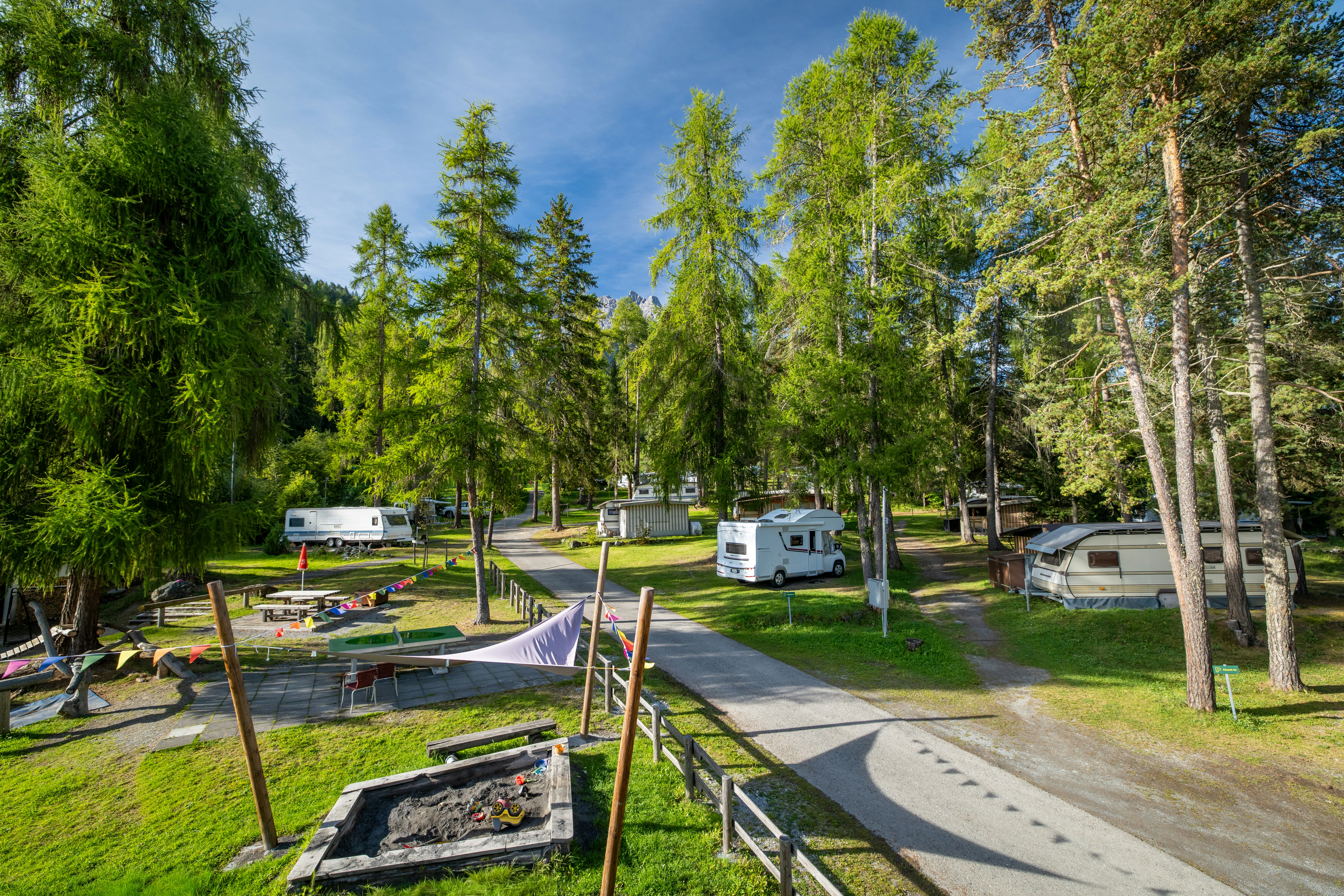 TCS-Camping Scuol - Standplätze zwischen den Bäumen auf dem Campingplatz