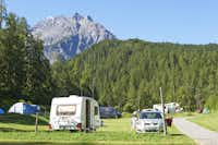 TCS-Camping Scuol - Wohnwagenstellplätze und Zeltplätze auf der Wiese mit Blick auf die Berge