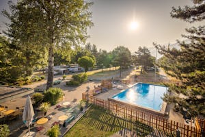 TCS Camping Sion - Blick auf den Campingplatz mit Pool im Freien und Terrasse