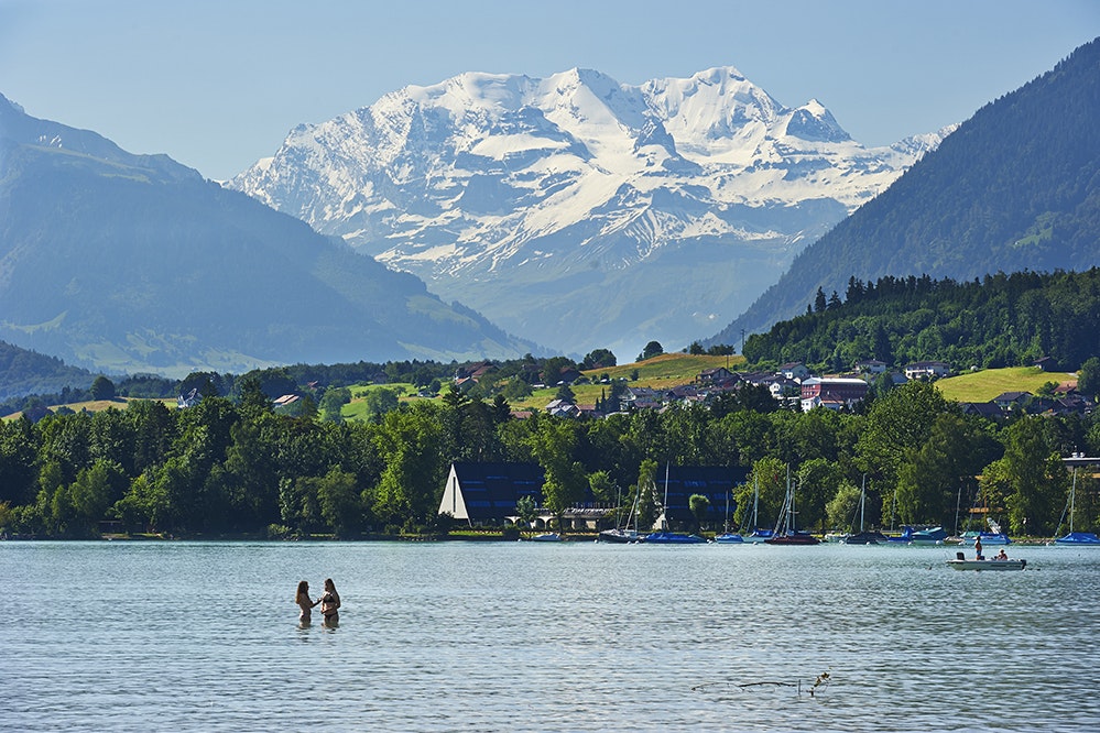 TCS-Camping Thunersee - Campinggäste baden im Tunersee mit Blick auf die Berge