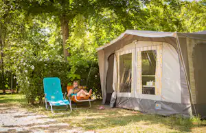 Thermalcamping Castrum Hajdúböszörmény - Sitzender Camper vor dem Zelt auf der Wiese der Campingplatzanlage