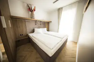 Thermen Chalets - Schlafzimmer mit Doppelbett in einem Mobilheim