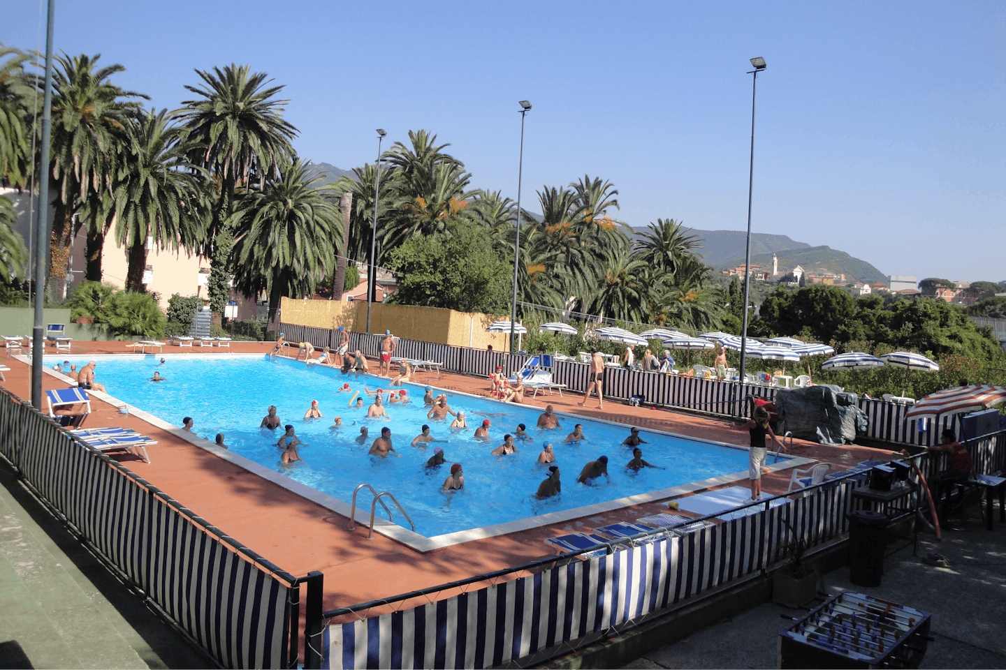 Tigullio Camping e Resort - Pool mit Liegestühlen und Sonnenschirmen auf dem Campingplatz