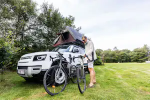 Tipperne Camping - Camper mit Fahrrad und Auto auf der Standplatzwiese