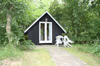 Tipperne Camping - kleine, gemütliche Holzhütte mit Terrasse im Grünen zwischen Bäumen