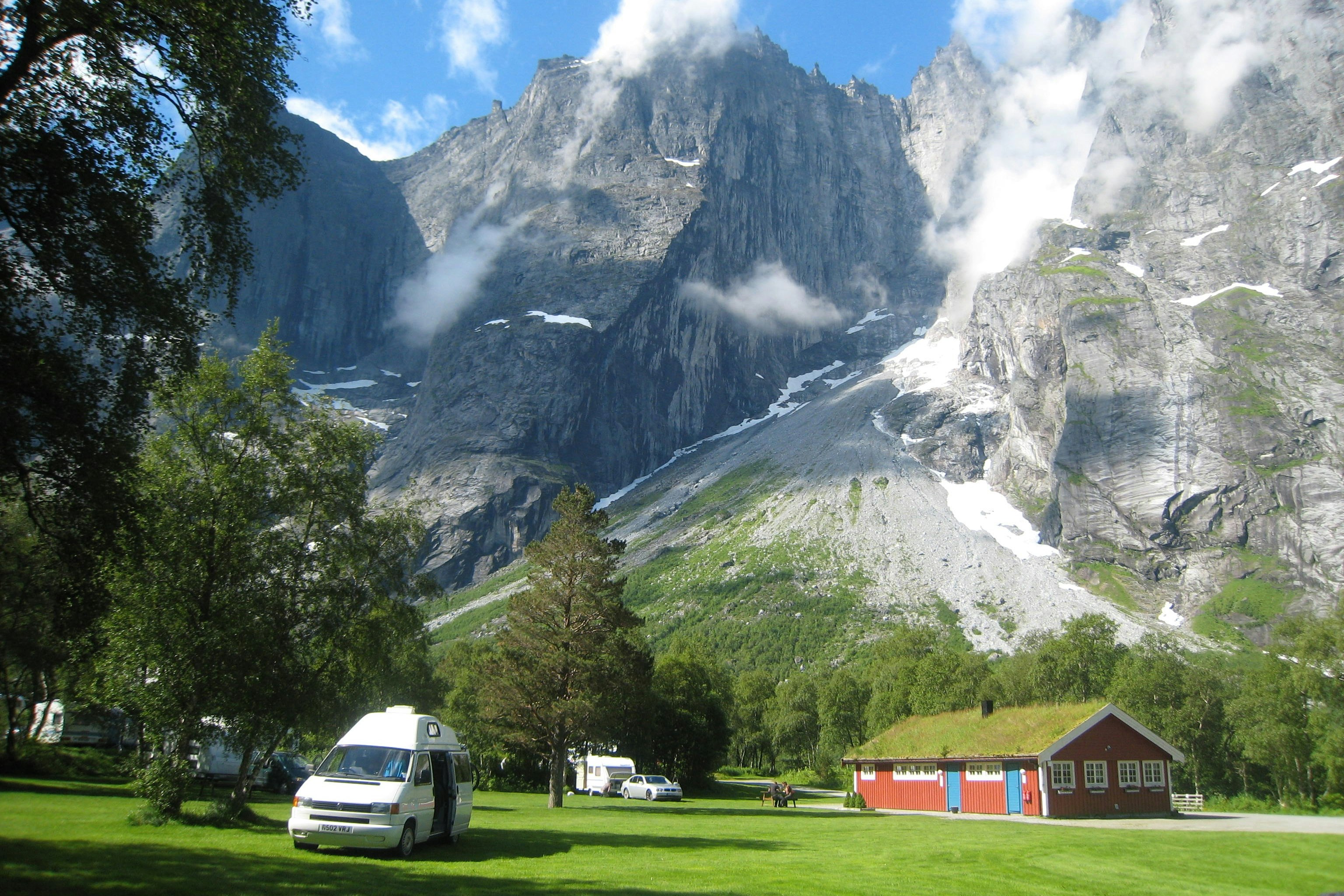 Trollveggen Camping - Blick auf die Standplatzwiese mit Bergen im Hintergrund