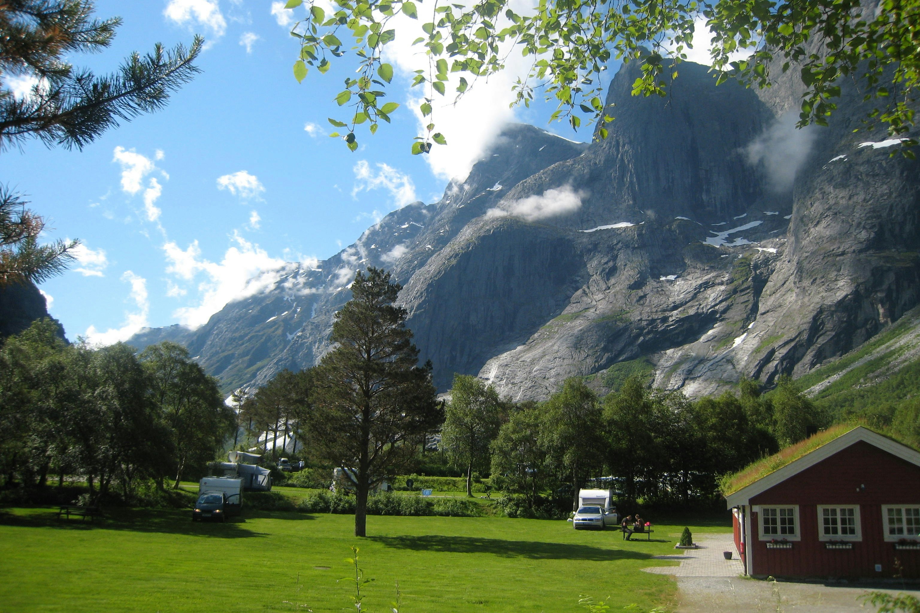 Trollveggen Camping - Wohnmobil- und Wohnwagenstandplätze auf der Wiese mit Bergen im Hintergrund