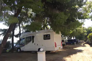 Tsoli's Camping - Wohnwagenstellplatz vom Campingplatz unter Bäumen mit Blick auf das Meer