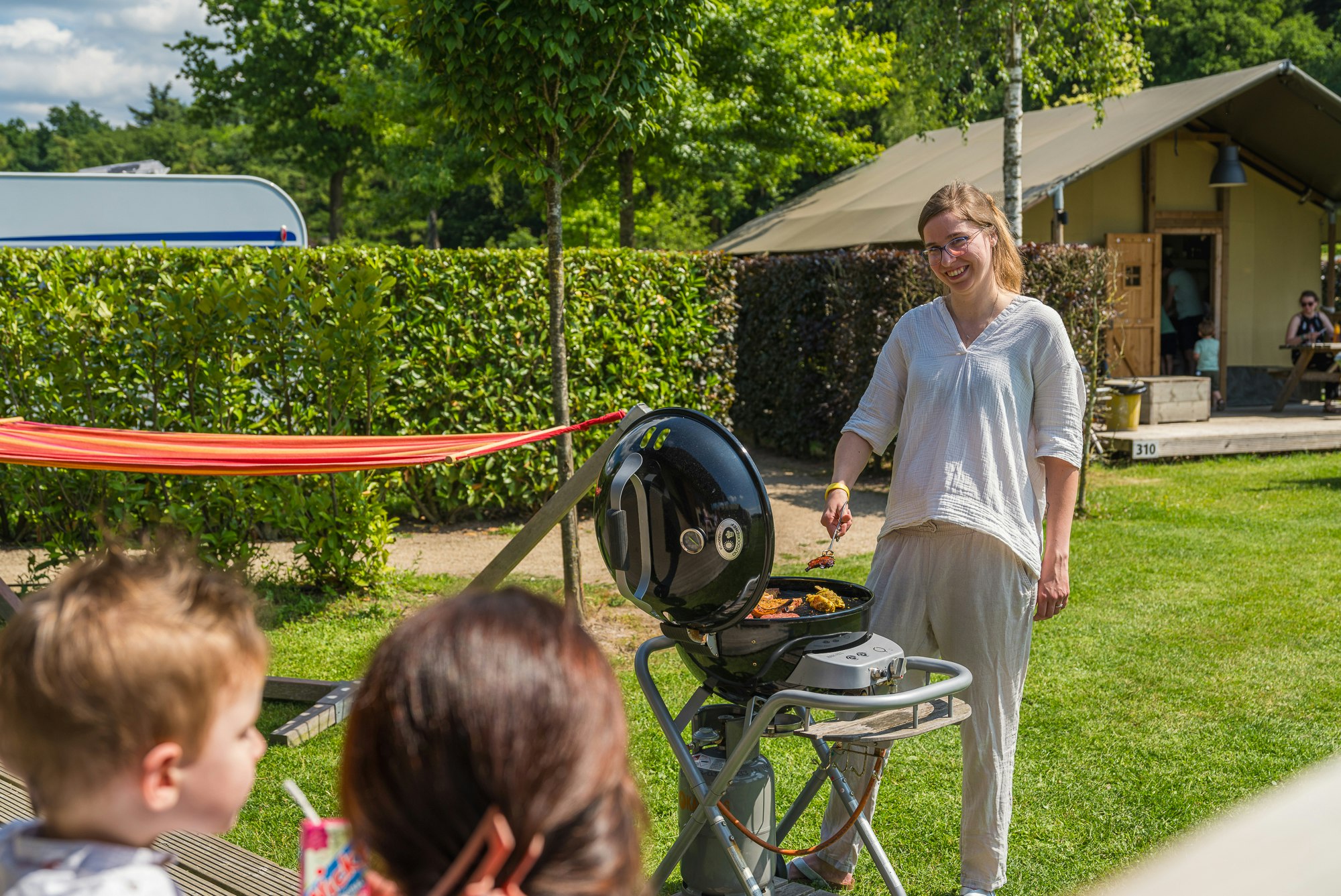 Ardoer Vakantiepark Ackersate - Familie beim Grillen auf der Terrasse eines Mobilheims