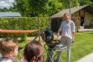 Ardoer Vakantiepark Ackersate - Familie beim Grillen auf der Terrasse eines Mobilheims