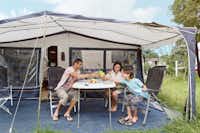 Vakantiepark Dierenbos  - Familie vor dem Wohnmobil auf dem Campingplatz im Grünen