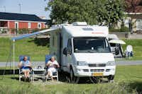 Vakantiepark Eiland van Maurik -  Camper sitzen vor dem Wohnmobil im Schatten der Markise--
