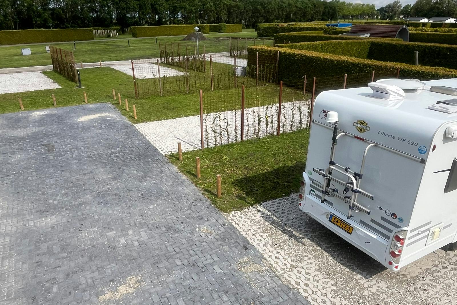 Vakantiepark in Style parzellierte, durch Hecken oder Zäune voneinander abgetrennte Standplätze mit teilweise gepflastertem und mit Gras bewachsenem Untergrund