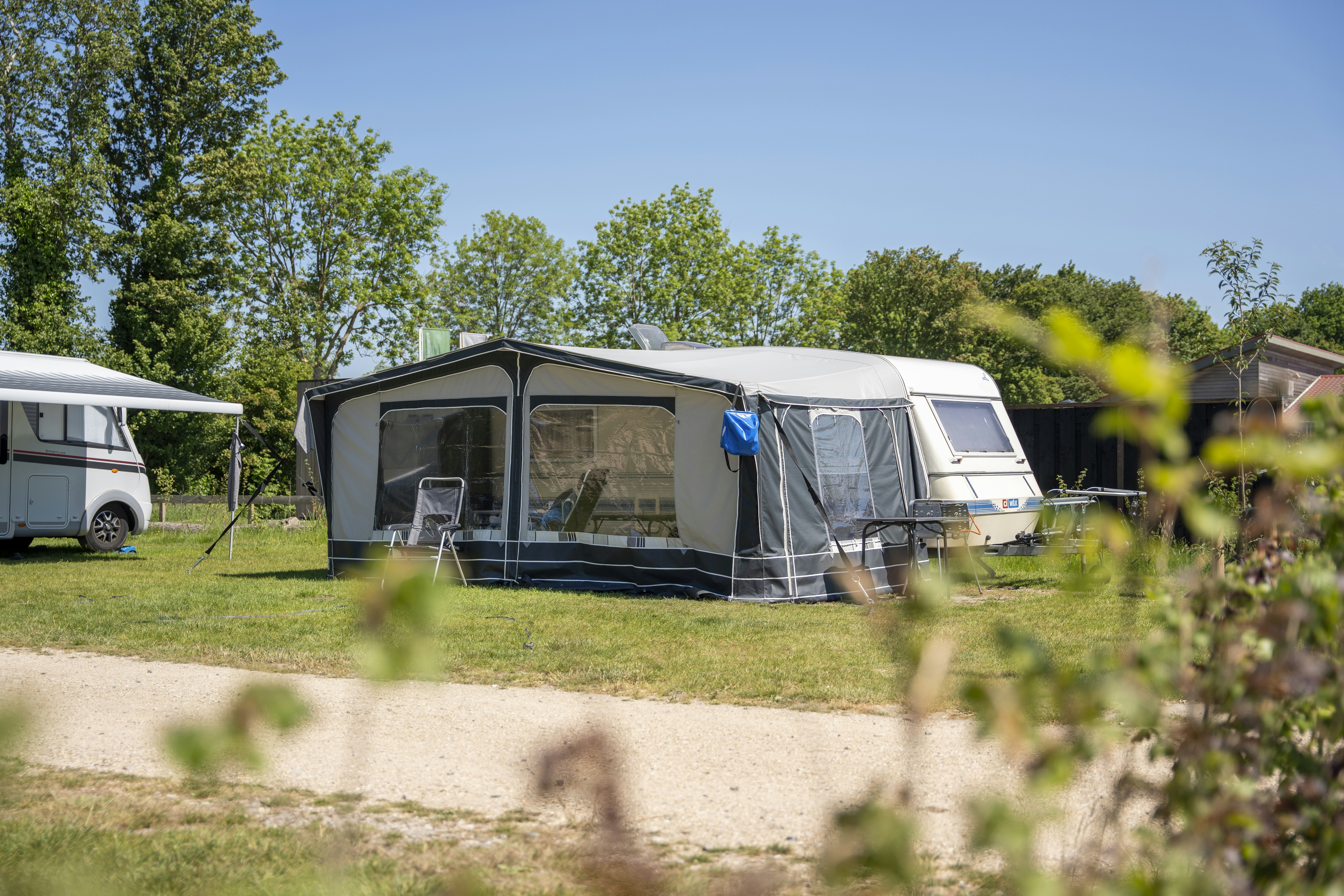 Vakantiepark Lemmer - Blick auf einen Wohnwagen mit Vorzelt auf der Standplatzwiese