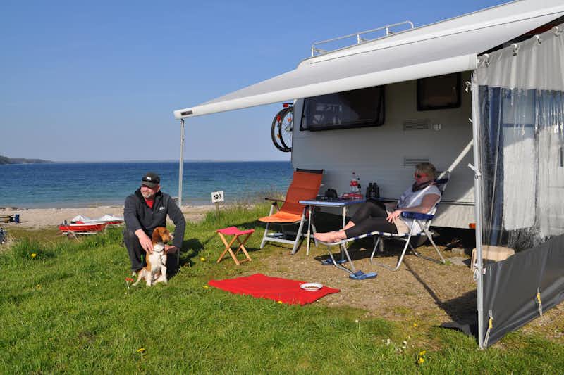 Vikær Strand Camping - Camper sitzen vor dem Wohnmobil im Schatten der Markise--
