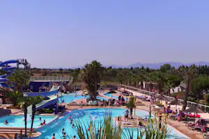 Camping le Marisol - Poolbereich mit Rutsche und mit Liegestühlen und Sonnenschirmen am Rand