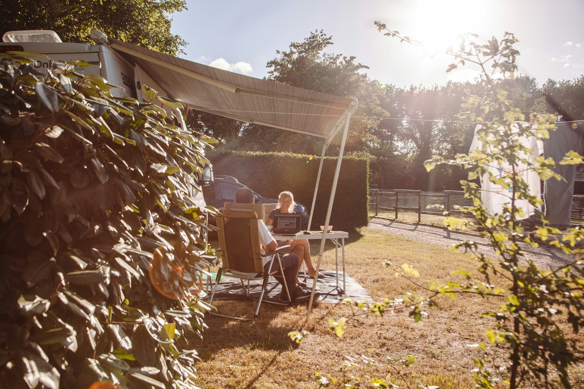 Camping Village de la Guyonnière - Camper sitzen vor ihrem Wohnmobil auf einem Standplatz