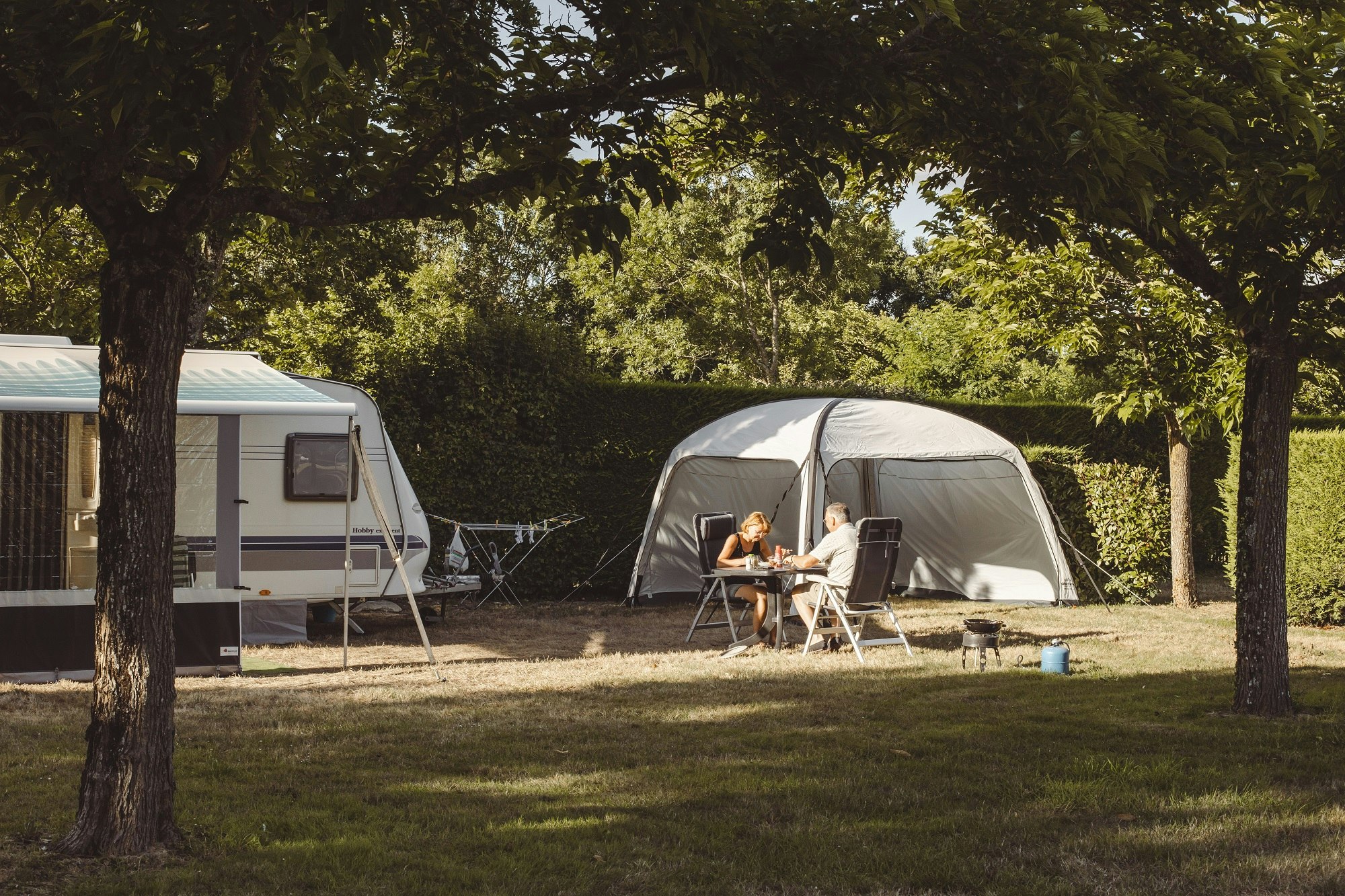 Camping Village de la Guyonnière - Standplätze zwischen den Bäumen auf dem Campingplatz