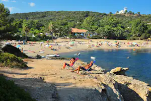 Village de Vacances Naturiste La Chiappa - sonnenbadende Camper am Strand vom Campingplatz