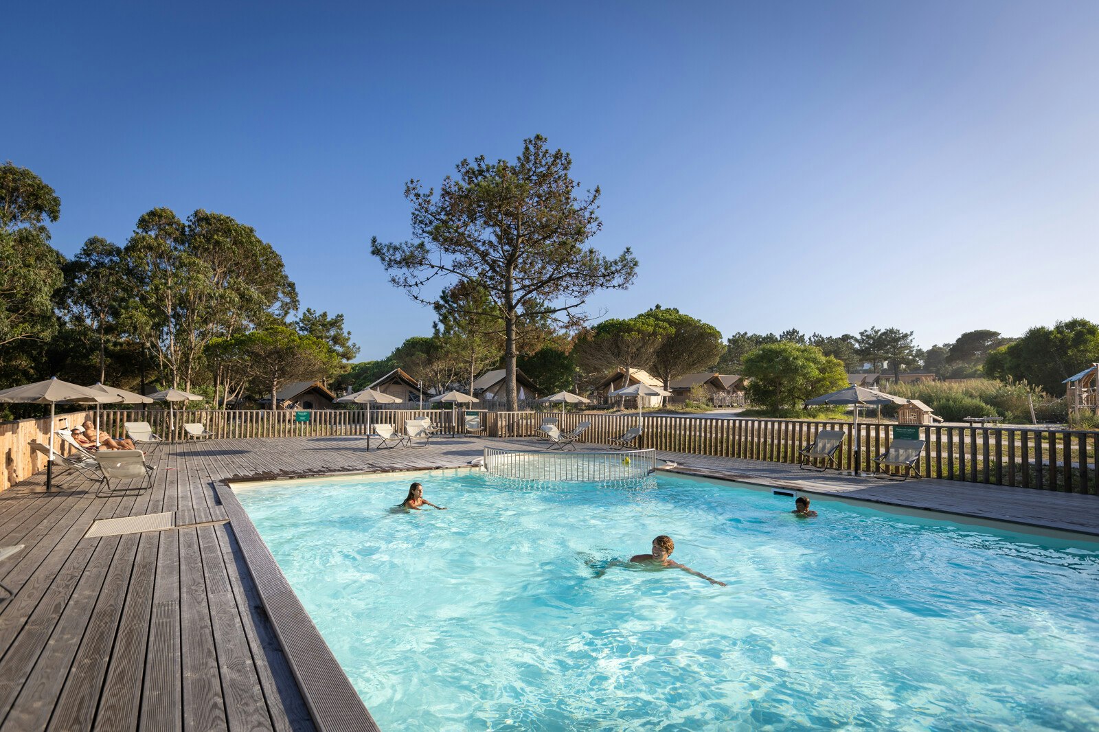 Huttopia Lagoa de Óbidos - Blick auf den Pool mit Liegestühlen und Sonnenschirmen