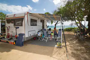 Villaggio Camping Capo Ferrato - Gäste im Schatten vor ihrem Wohnmobil mit Blick auf das Meer