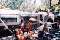 Villaggio Camping La Zagara - Camperfamilie vor ihrem Wohnwagen  im Schatten der Bäume