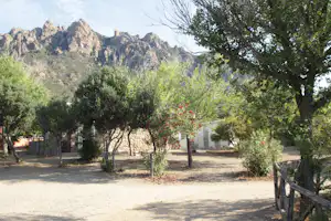 Villaggio Camping Tesonis - Blick auf das Sanitärgebäude vom Campingplatz, Berge im Hintergrund