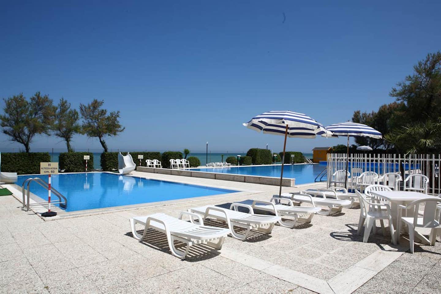 Villaggio Le Mimose  -  Pool vom Campingplatz mit Liegestühlen in der Sonne und blick auf das Mittelmeer auf Sardinien