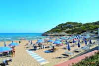 Villaggio Turistico Baia di Manaccora  -  Strand vom Campingplatz mit Sonnenschirmen und Liegestühlen am Mittelmeer