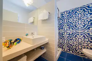 Villaggio Turistico Baia di Manaccora - Sanitärbereich vom Campingplatz mit Waschbecken, Spiegeln, Dusche und Toilette