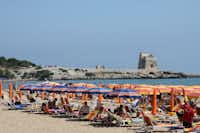 Villaggio Turistico Grotta dell'Acqua  -  Strand vom Campingplatz am Mittelmeer mit Sonnenschirmen und Liegestühlen