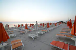 Villaggio Turistico Le Dune - Strand vom Campingplatz mit Sonnenschirmen und Liegestühlen bei Sonnenuntergang