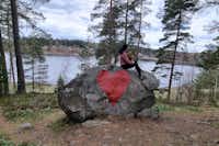 Vimmerby Camping Nossenbaden - Camperin sitzt auf einem Felsen und blickt auf den See