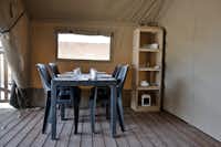 Vodatent @ De Vrolijke Flierefluiter - Innenansicht Mietunterkunft mit gedecktem Tisch und Regal mit Geschirr
