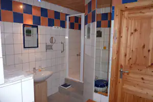 Waldcampingplatz Erzgebirgsblick - Sanitärgebäude mit Waschbecken, Spiegel, Toiletten und Duschen