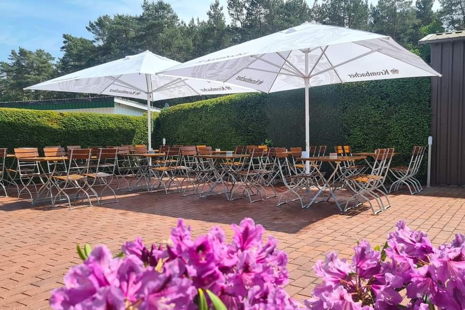 Waldesruh Camping CMA  Watercamp Waldesruh - Biergarten mit Tischen, Stühlen und schattenspendende Sonnenschirme