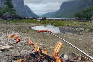 Wathne Camping - Camper grillen Würstchen über dem Lagerfeuer