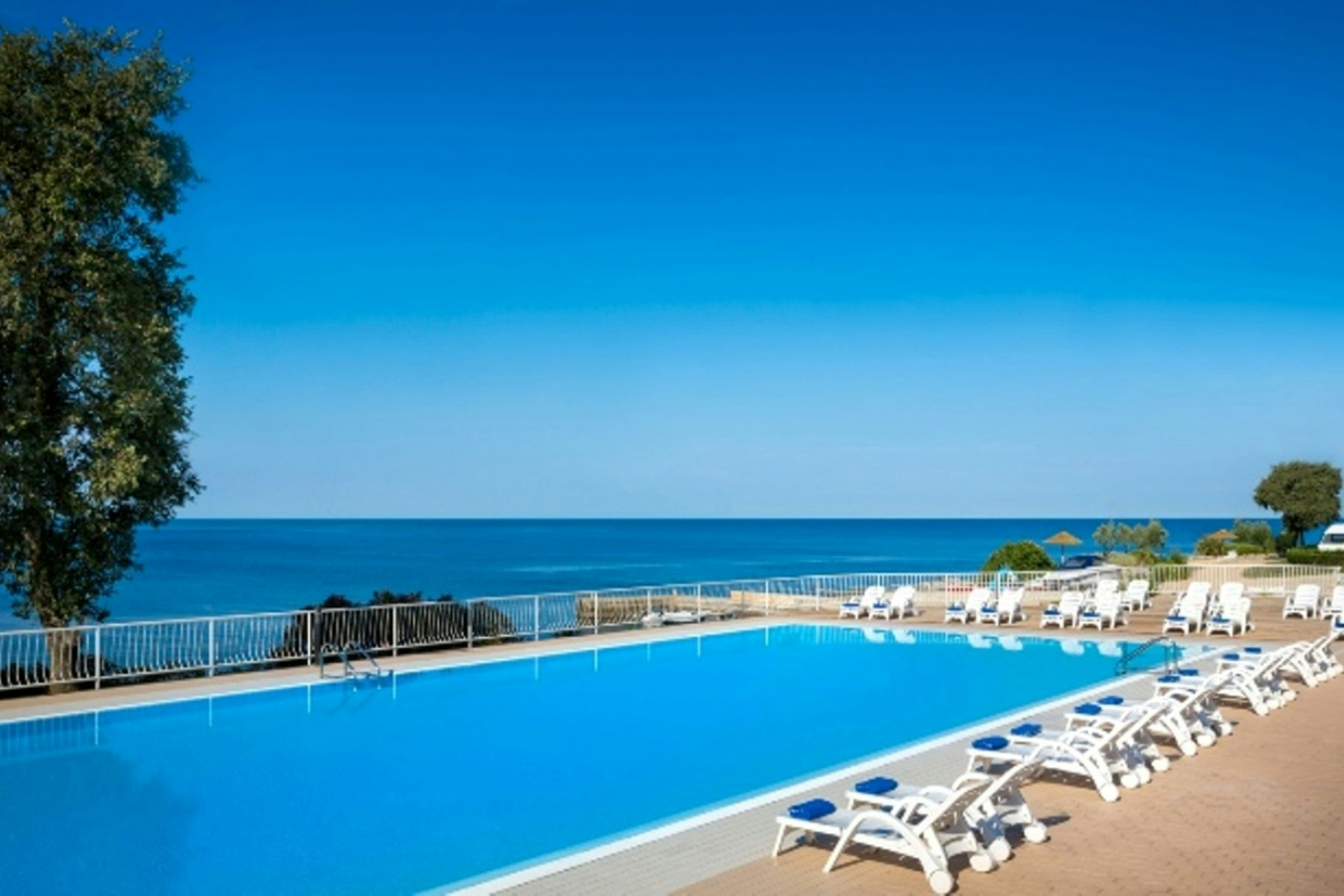 WestCoast Mobile Homes @ Solaris Camping  - Pool im Freien mit Liegestühlen und Blick auf das Meer