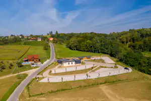 Campinganlage inmitten von Weinbergen, mit Wegen, Stellplätzen und mehreren Gebäuden in grüner Landschaft.